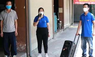 Cán bộ đoàn đến vận động mời bảo vệ nhà hàng đi xét nghiệm, tiêm vắc xin. Ảnh: .N.L