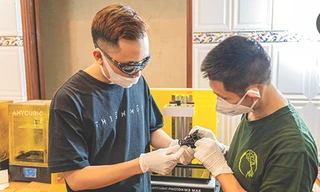 Hoàng Anh Tuấn (bên trái) đang vận hành máy in 3D 