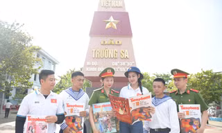 Hoa hậu Đỗ Thị Hà (thứ 4 từ trái qua) cùng các chiến sĩ ở đảo Trường Sa đọc báo Tiền Phong Ảnh: Dương Triều