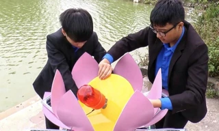 Hai em Hiếu (bên trái) và Đạt lắp ráp sản phẩm trước khi đưa xuống hồ chạy thử nghiệm 