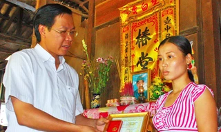 Anh Phan Văn Mãi trao huy hiệu “Tuổi trẻ dũng cảm” (của T.Ư Đoàn truy tặng đoàn viên Huỳnh Văn Tùng) cho vợ anh Tùng