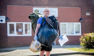 Thầy giáo đi bộ đem thức ăn cho học sinh