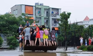 Người dân phải dùng xe xúc để đi qua các điểm ngập sâu.
