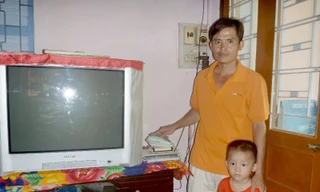 Anh Trần Công Lê bên máy điện thoại và các dịch vụ của VNPT Tiền Giang cung cấp.