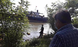 Lực lượng chức năng đưa thi thể nạn nhân vào bờ. Ảnh: T.C