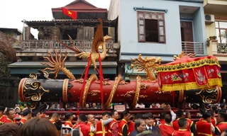 Mỗi quả pháo được thanh niên trong làng thay nhau khiêng từ nhà văn hóa truyền thống của làng Đồng Kỵ đến sân đình để làm lễ. Ảnh: Nguyễn Thắng