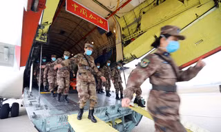Các nữ y tá, bác sĩ quân y rời máy bay khi tới sân bay ở Vũ Hán. Ảnh: China Daily.