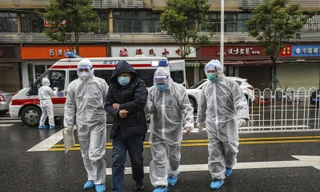 Các nhân viên y tế giúp một bệnh nhân ở thành phố Vũ Hán, tỉnh Hồ Bắc ngày 26/1. Ảnh: AP.