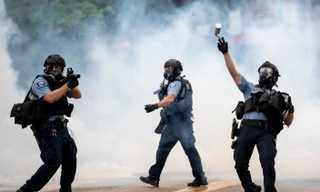 Cảnh sát ném lựu đạn cay về phía người biểu tình ở thành phố Minneapolis (Mỹ) ngày 26/5. Ảnh: AP.