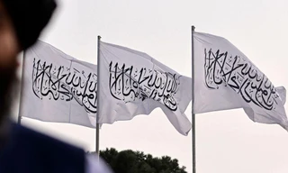 Một chiến binh Taliban được chụp trên nền cờ Taliban được cắm tại sân bay quốc tế Hamid Karzai ở thủ đô Kabul của Afghanistan ngày 11/9/2021. Ảnh: Getty Images.