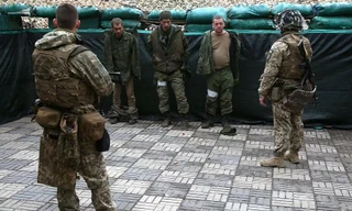 Lực lượng Ukraine bắt giữ các quân nhân của Cộng hòa Nhân dân Lugansk tự xưng - những người tham gia tấn công thị trấn Schast'ye ở miền đông Ukraine. Ảnh: Getty Images.