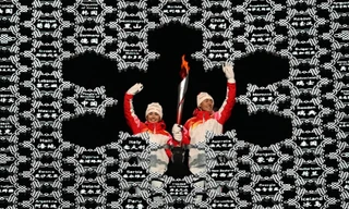 Hai VĐV trượt tuyết băng đồng Dinigeer Yilamujiang (trái) và Zhao Jiawen đặt ngọn đuốc vào giữa vạc lửa Olympic hình bông tuyết. Ảnh: Getty Images.