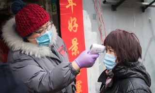 Kiểm tra thân nhiệt một cư dân thành phố Vũ Hán, tỉnh Hồ Bắc, Trung Quốc ngày 7/2. Ảnh: Xinhua.