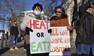 Những người Anh cầm biểu ngữ (Sưởi ấm hay ăn/Tất cả chúng tôi cần sự ấm áp) trong một cuộc biểu tình kêu gọi chính phủ giúp đỡ người dân chi trả hóa đơn năng lượng của họ. Ảnh: AP.