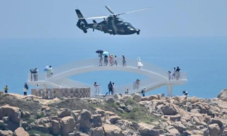 Du khách ngày 4/8 nhìn trực thăng quân sự của Trung Quốc bay qua đảo Pingtan, một trong những điểm của Trung Quốc đại lục gần Đài Loan nhất. Ảnh: Getty Images.