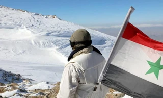 Một binh sĩ Syria mang quốc kỳ Syria. Ảnh: SANA/RT. 