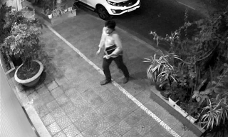 Người đàn ông Hàn Quốc đi vòng quanh xe ô tô đang đỗ trước cửa nhà ông Linh. Ảnh cắt từ camera an ninh