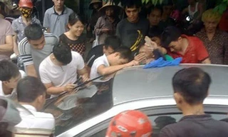 Mọi người cố gắng phá cửa xe giải cứu bé trai bị bố bỏ quên.