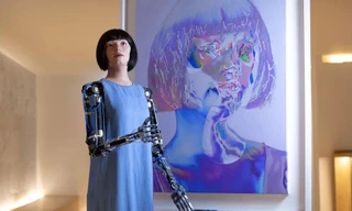 Người máy Ai-Da và bức chân dung tự họa của cô tại triển lãm ở London.