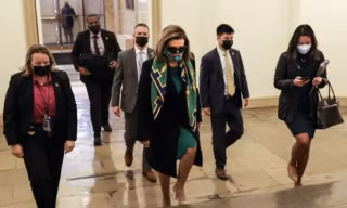 Chủ tịch Hạ viện Mỹ Nancy Pelosi ( giữa) và các hạ nghị sỹ bước vào bỏ phiếu thông qua gói cứu trợ COVID-19.