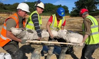 Các nhà khai quật khệ nệ khiêng hài cốt voi ma mút vừa được tìm thấy.