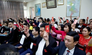 Các đại biểu biểu quyết thông qua Nghị quyết của Đại hội Đảng bộ. (Ảnh: Phạm Kiên/TTXVN)