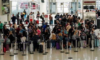 Du khách chờ làm thủ tục ở sân bay quốc tế John F. Kennedy ở TP New York, Mỹ, ngày 6/4. (Ảnh: Reuters)
