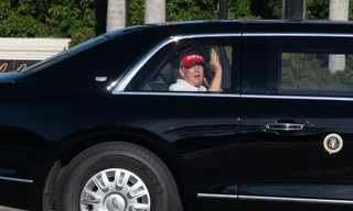 Tổng thống Mỹ Donald Trump vẫy tay khi đang ngồi trên chiếc limousine trở về khu biệt thự và sân golf của ông ở West Palm Beach ngày 8/3. (Ảnh: AP)