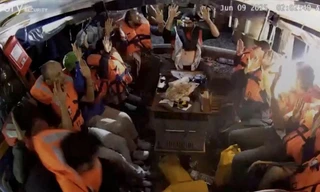 Ảnh từ camera giám sát cho thấy các thành viên trên tàu giơ tay lên cao khi có một chùm sáng mạnh chiếu về phía họ. (Ảnh: FFC)