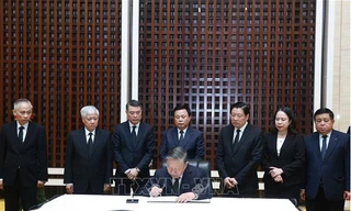 Tổng Bí thư Tô Lâm ghi sổ tang đồng chí Khamtay Siphandone. (Ảnh: TTXVN)