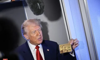 Tổng thống Mỹ Donald Trump khoe chiếc thẻ vàng in hình ông. (Ảnh: NYT)