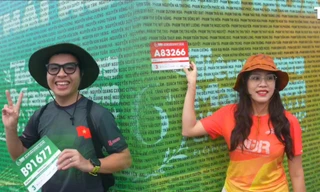 Runner háo hức check-in bảng tên dưới mưa, sẵn sàng chinh phục Tiền Phong Marathon 2025