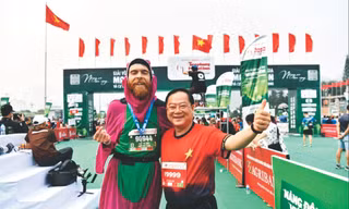 Nhà báo Lê Xuân Sơn - Tổng Biên tập báo Tiền Phong, đồng Trưởng Ban tổ chức Tiền Phong Marathon, chung vui cùng VĐV Liam Watson tại vạch đích