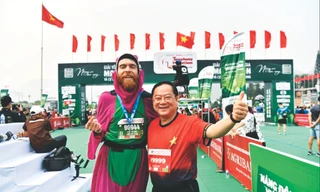 Nhà báo Lê Xuân Sơn - Tổng Biên tập báo Tiền Phong, đồng Trưởng Ban tổ chức Tiền Phong Marathon, chung vui cùng VĐV Liam Watson tại vạch đích