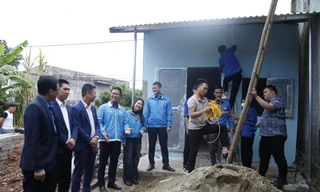 Đoàn viên Trường Cao đẳng Kỹ thuật Công nghiệp Bắc Giang làm đường dây điện giúp nhà bà Lường Thị Mèo Ảnh: Nguyễn Thắng 