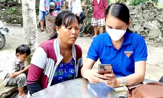 Cán bộ Đoàn Thanh niên ở Hậu Giang đi từng nhà vận động, hướng dẫn người dân cài đặt, sử dụng dịch vụ công trực tuyến, thanh toán không tiền mặt trên điện thoại thông minh Ảnh: Cảnh Kỳ