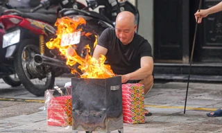 Người dân có thói quen sắp mâm lễ cúng, đốt vàng mã ngay tại vỉa hè, lòng đường Ảnh: DUY PHẠM