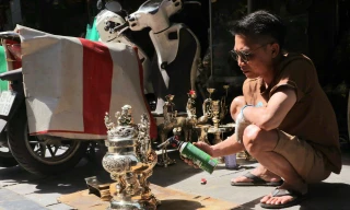 Ông Sơn đang sơn bóng đồ đồng