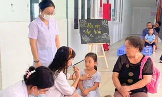 Bác sĩ khám sàng lọc sức khỏe cho học sinh ở quận 7, TPHCM trước khi tiêm vắc xin phòng bệnh sởi ảnh: Phú Khánh 