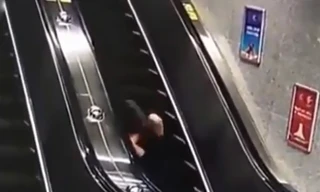Người phụ nữ mất thăng bằng, ngã lộn nhiều vòng trên thang cuốn. Ảnh cắt từ clip.