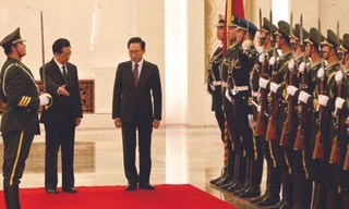 Chủ tịch quốc hội Hồ Cẩm Đào (trái) mời Tổng thống Lee Myung-bak duyệt đội danh dự tại lễ đón. Ảnh AP