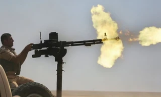 Một chiến binh YPG đang nã đạn liên hoàn từ khẩu đại liên hạng nặng. Ảnh: Janes