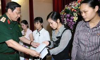 Trung tướng Nguyễn Hùng Mạnh, Chính ủy Bộ Tư lệnh Thủ đô, trao tiền hỗ trợ các gia đình. Ảnh: Trọng Đức/TTXVN