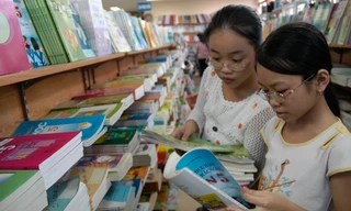  Học sinh tiểu học lựa chọn sách giáo khoa tại một cửa hàng sách trên đường Lý Thường Kiệt (Hà Nội). Ảnh: Hồng Vĩnh