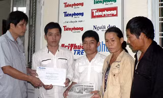 Đại diện báo Tiền Phong trao số tiền bạn đọc giúp đỡ cho hai anh em Danh - Thành với sự có mặt của ba mẹ hai em (ảnh chụp tháng 9/2009). ảnh: N.H