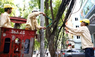 Công ty chiếu sáng và thiết bị đô thị Hà Nội dọn “rác trời” trên phố Quang Trung. ảnh: Như Ý