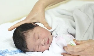 Dùng nước muối sinh lý để vệ sinh mũi cho trẻ.