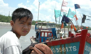 Cảng cá đìu hiu. Bé Đỗ 13 tuổi không biết chữ đang đợi bố đánh cá trở về. Ảnh: T.N.A 