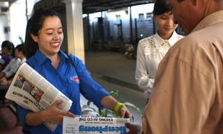 Sinh viên tình nguyện phát báo Tiền Phong cho phụ huynh. Ảnh: Mai Xuân Tùng