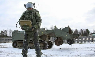 Một binh sỹ Nga mang bộ giáp hỗ trợ để điều khiển robot phá mìn Uran-6